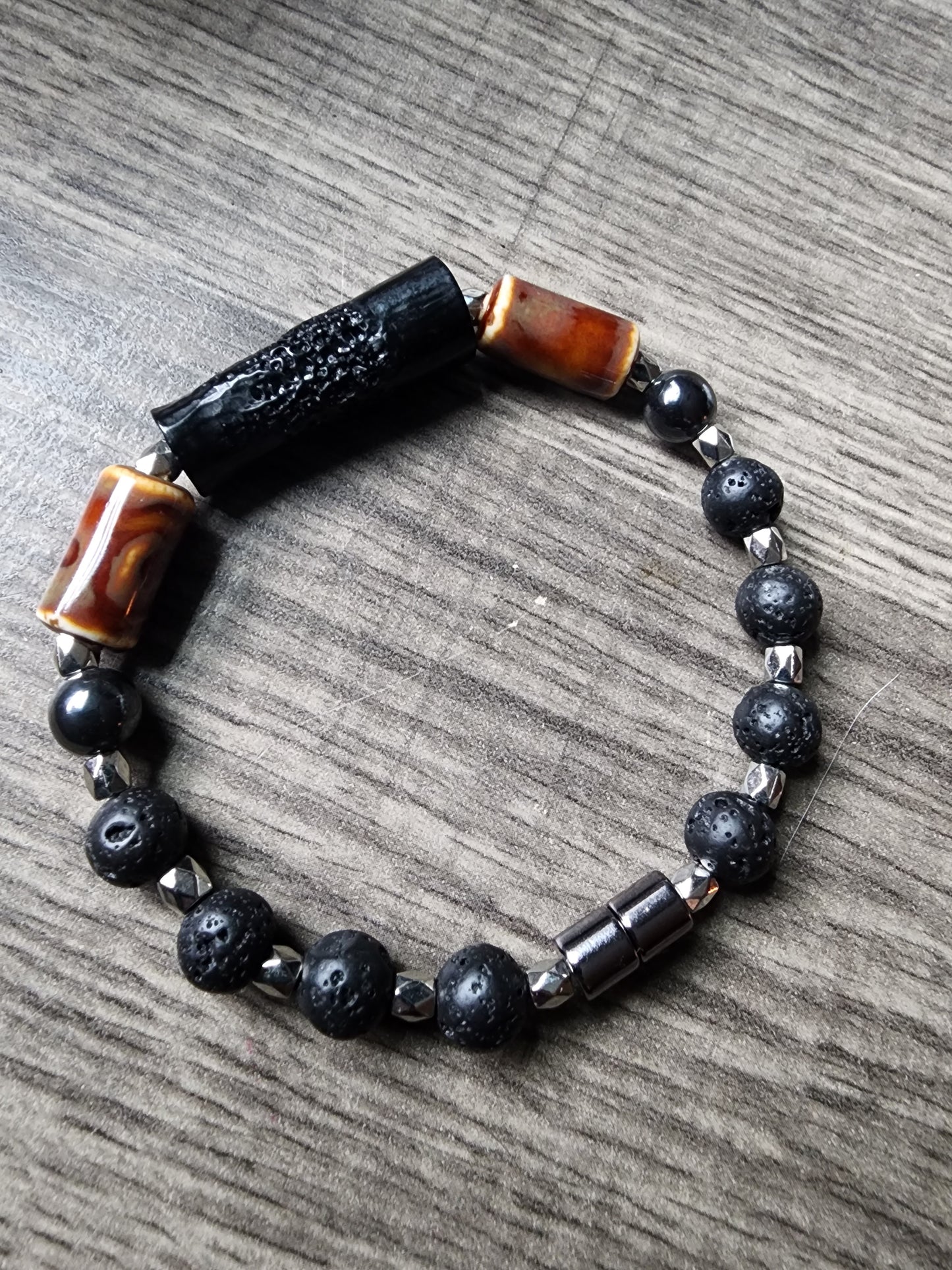 8" Hematite and black lava stone bracelet with brown glass bead and silver accents